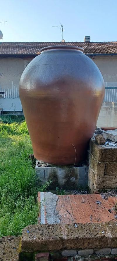 UN ORCIO RITENUTO DI TERRACOTTA COLOR MATTONE CEMENTATO ALLA BASE E SUL LATO POSTERIORE  
