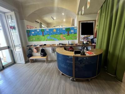 Mobile ingresso/bancone composto da due pezzi in legno chiaro, forma (due semicerchi), con pannelli rivestiti in materiale metallico blu forato, completo di ruote. Valore di € 1.500,00.