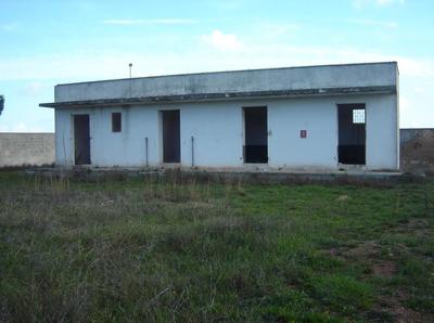 fabbricato con diversi piccoli vani su lotto di terreno incolto di forma trapezoidale recintato e adibito a ex deposito e distribuzione di carburanti per uso agricolo, oramai in disuso.