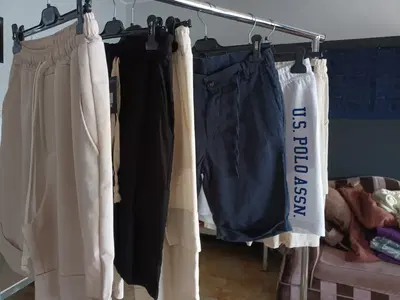 tavolo legno, specchio con cornice, mobiletto basso, 6 pantaloncini in stoffa, 10 pantaloni lunghi colori e modelli assortiti.