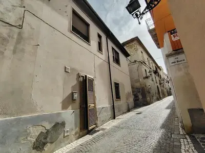 Appartamento composto al piano terra da ingresso con scala di accesso al piano superiore, soggiorno – cucina, ripostiglio sottoscala, disimpegno e wc , al piano primo da soggiorno (attualmente ad uso camera) con adiacente cucinino, due camere , disimpegno, bagno , due ripostigli e terrazzino sul lato nord.