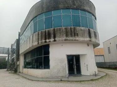 Fabbricato ad uso produttivo (industriale/artigianale) a due piani fuori terra con copertura piana praticabile e dotato di ascensore, destinato prevalentemente per le attività degli uffici amministrativi, commerciali, tecnici di progettazione e prototipazione, oltre ad un’area destinata a laboratorio produttivo con piccoli depositi e magazzini, con area esterna di pertinenza esclusiva e stradina di accesso. Libero