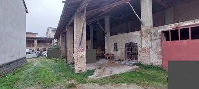 Fabbricato ad uso deposito-porticato con annessa area pertinenziale composto al piano terra, da tre locali di deposito con annessa tettoia e due solai al piano primo, cui si accede mediante scala in appoggio. All’esterno, in corpo distaccato vi è un ulteriore deposito con sovrastante solaio. Completa il lotto l’area esclusiva su cui vi erano altri due locali di deposito, ormai crollati.