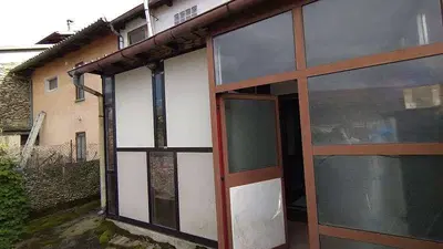A) compendio con cortile di pertinenza così composto:= due piani fuori terra oltre sottotetto, con: al piano terreno soggiorno con cucina a vista e servizi, piccola corte esclusiva con tettoia chiusa; al piano primo due camere e servizi; al piano sottotetto, area non abitabile;= tettoia chiusa al piano terreno, con due locali ad uso deposito= corte pertinenziale con veranda e piccola area barbecueB) terreni pertinenziali che costituiscono un giardino pertinenziale e il viottolo di accesso al fabbricato 