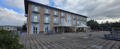 fabbricato destinato ad albergo (n° 32 camere), con area cortilizia adibita a parco, ed a parcheggi privati interni ed esterni (piazzetta frontale), entrambi con pavimentazione asfaltata, dislocato al piano primo e secondo, con ristorante al piano terreno; oltre a piano interrato. Il tutto servito da scala interna e ascensore. 
