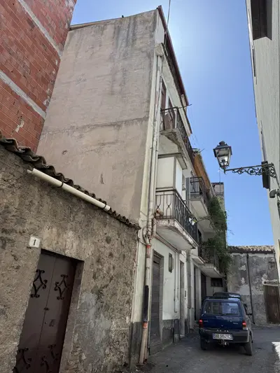 diritto di piena proprietà di appartamento per civile abitazione ubicato ad Adrano (CT), in via Scuderia con ingresso al n. 5, posto ai piani primo, secondo e terzo, comunicanti tramite scala interna, composto da 3 vani + bagno + due balconi + veranda + wc esterno + deposito + terrazzo