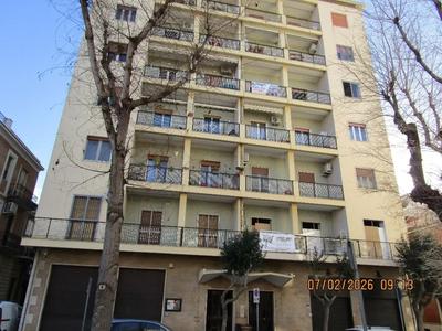 Appartamento dalla superficie commerciale è di 129 mq. Ha balconi, con affaccio su via Perseo e via Trieste. E’ posto al 5° piano, raggiungibile con ascensore e scala, l’accesso è la prima porta a sinistra salendo dalle scale. È composto da un ampio ingresso, un vano cucina abitabile un soggiorno di ampia dimensione, una camera da letto, una cameretta, due ripostigli e un bagno.