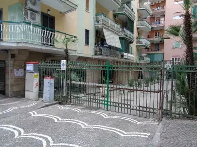 Piena ed intera proprietà di appartamento a destinazione residenziale sito in Portici (NA) alla Via Benvenuto Cellini n. 50, scala A, piano sesto, composto da soggiorno-cucina, sala da pranzo, n. 2 camere da letto, bagno, ripostiglio, disimpegno e n. 2 balconi. La superficie catastale totale è pari a 112 mq.