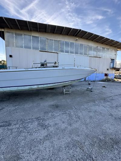 Imbarcazione di colore bianco con striscia blu, priva di motore, di circa metri 6 - carrello porta barche, targato AC51864