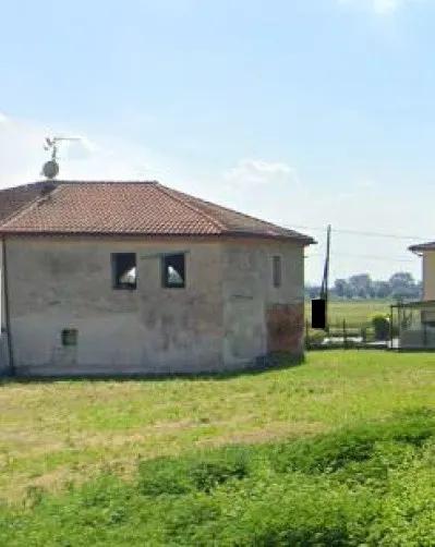 Piena proprietà per la quota di 1/1 di porzione di fabbricato allo stato grezzo con terreno di 5069 mq catastali, ex fabbricato rurale ad uso magazzino in pessimo stato di manutenzione ed in corso di ristrutturazione a fini conservativi, già adibito a stalla. Terreno tipologia agricola ma attualmente incolto e con sterpaglia. Libero. Vincoli e conformità come da Perizia a cui si rimanda per ogni specifica
