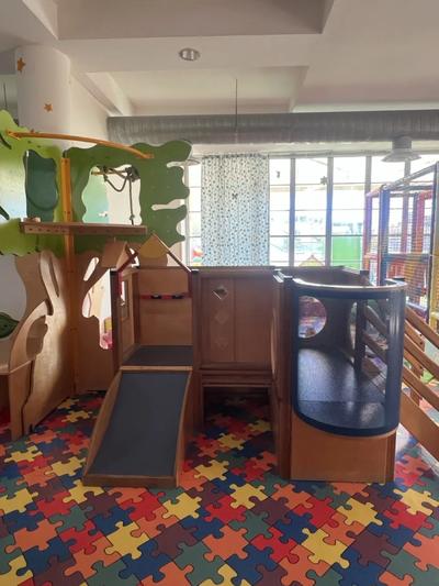 Struttura giochi in legno marca Gemino con due scivoli e casette sottostanti con giochi sensoriali e oblò trasparente con girasoli dipinti. Valore di € 8.000,00.