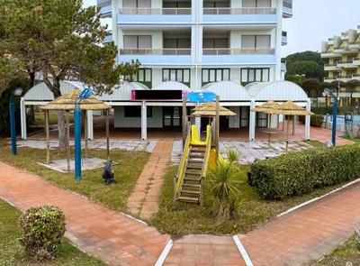Unità immobiliare a destinazione commerciale, precisamente a bar. L'ingresso a Bibione avviene da unica viabilità. La località Lido del Sole è raggiungibile da questa viabilità. L'unità tratta un pubblico esercizio ad attività bar con consumazioni in loco e per asporto. Essa insiste all'estremità del corpo Residence Le Zattere fronte mare. Si sviluppa al piano terra e da parziale soppalco. Occupata. Irregolarità edilizie e catastali; spese condominiali scadute ed insolute.