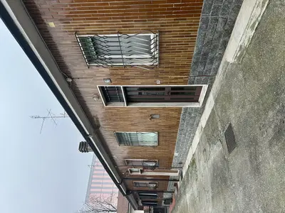 Piena proprietà di appartamento ad uso abitazione dotato di accesso indipendente e inserito in edificio a schiera, posto al piano terra (rialzato) composto da ingresso, disimpegno, soggiorno, cucina, camera e bagno, con annessi ripostiglio e area scoperta pertinenziale.