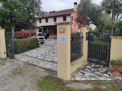 Per la quota di 1/1 di piena proprietà in regime di separazione dei beni - immobile su 2 piani f.t. composto da due unità residenziali (al piano terra e primo), un garage e area scoperta di pertinenza adibita ad accesso pedonale e carraio e ad area a verde; sono presenti una pompeiana in legno sul lato ovest, una tettoia metallica in aderenza all’immobile sul lato est e sul lato sud, in distacco dal fabbricato, sono presenti un manufatto in metallo e un prefabbricato in legno (uso magazzino)
